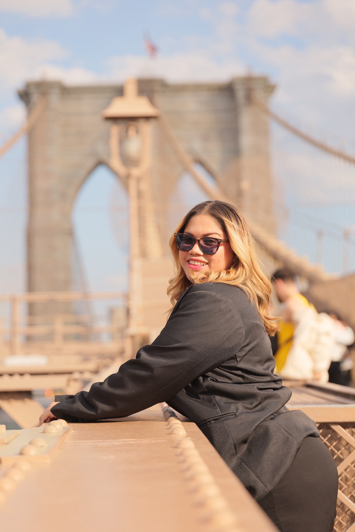 Nelcys Barreto in a black suit on the Brooklyn Bridge